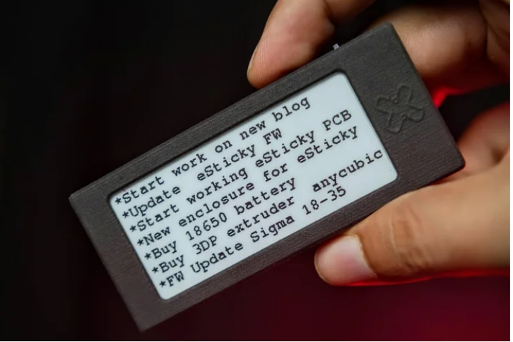 hand holding an e-ink device called ESticky
