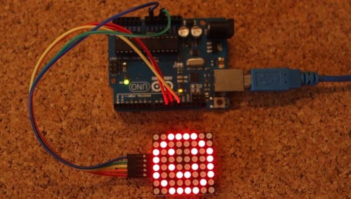 Arduino Uno wired to an 8×8 LED matrix showing a smiley face