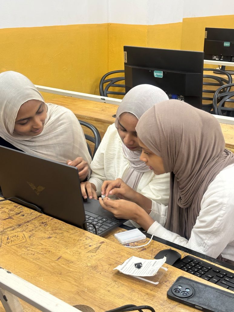 Students hands-on wiring components during a hardware build at EMEA College